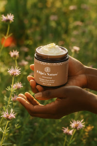 Golden Beauty Butter - #scent_Unscented  #size_16oz - Hands holding an Unscented jar of Elija’s Nature Golden Shea Butter in a field of wildflowers