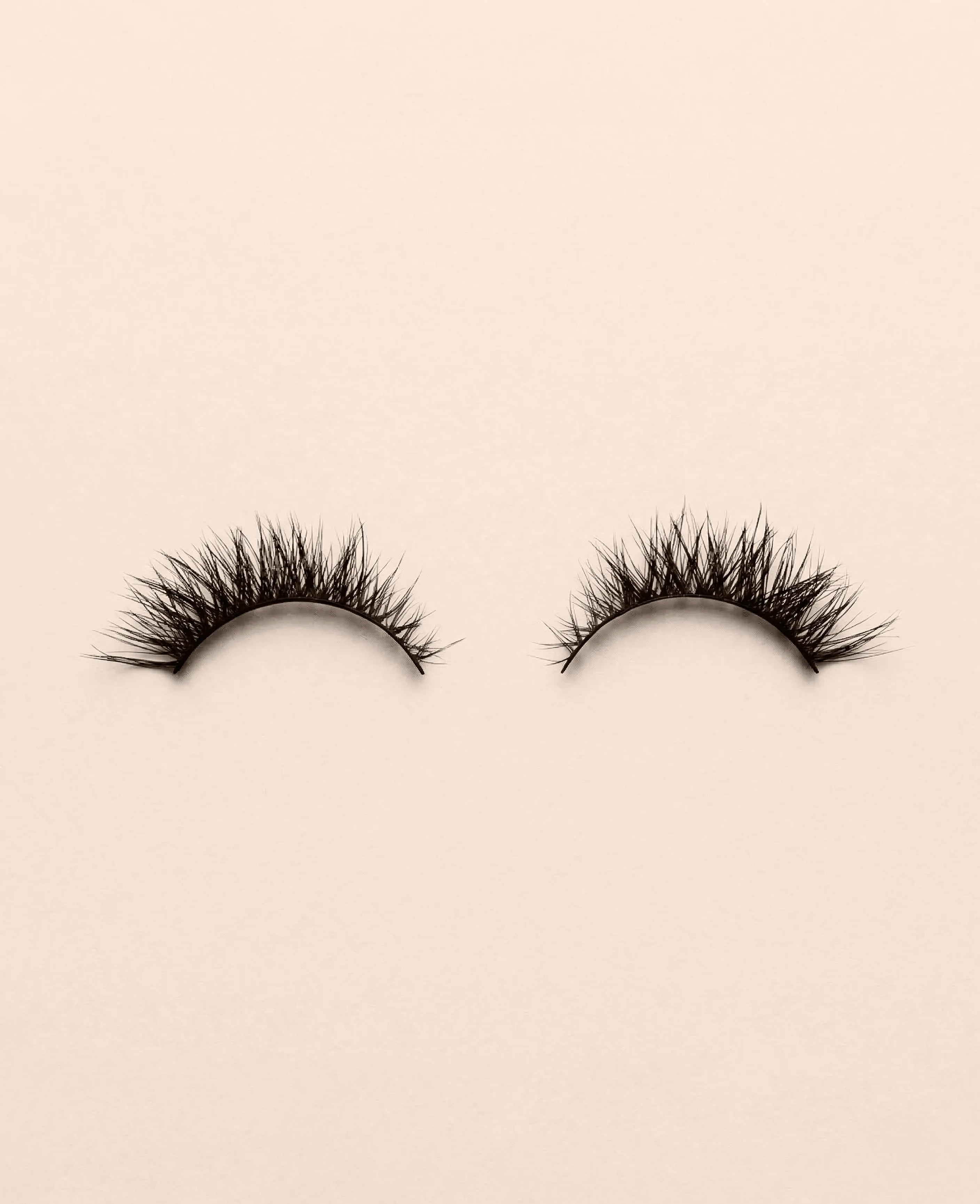 Pair of Silhouette false eyelashes on a beige background.