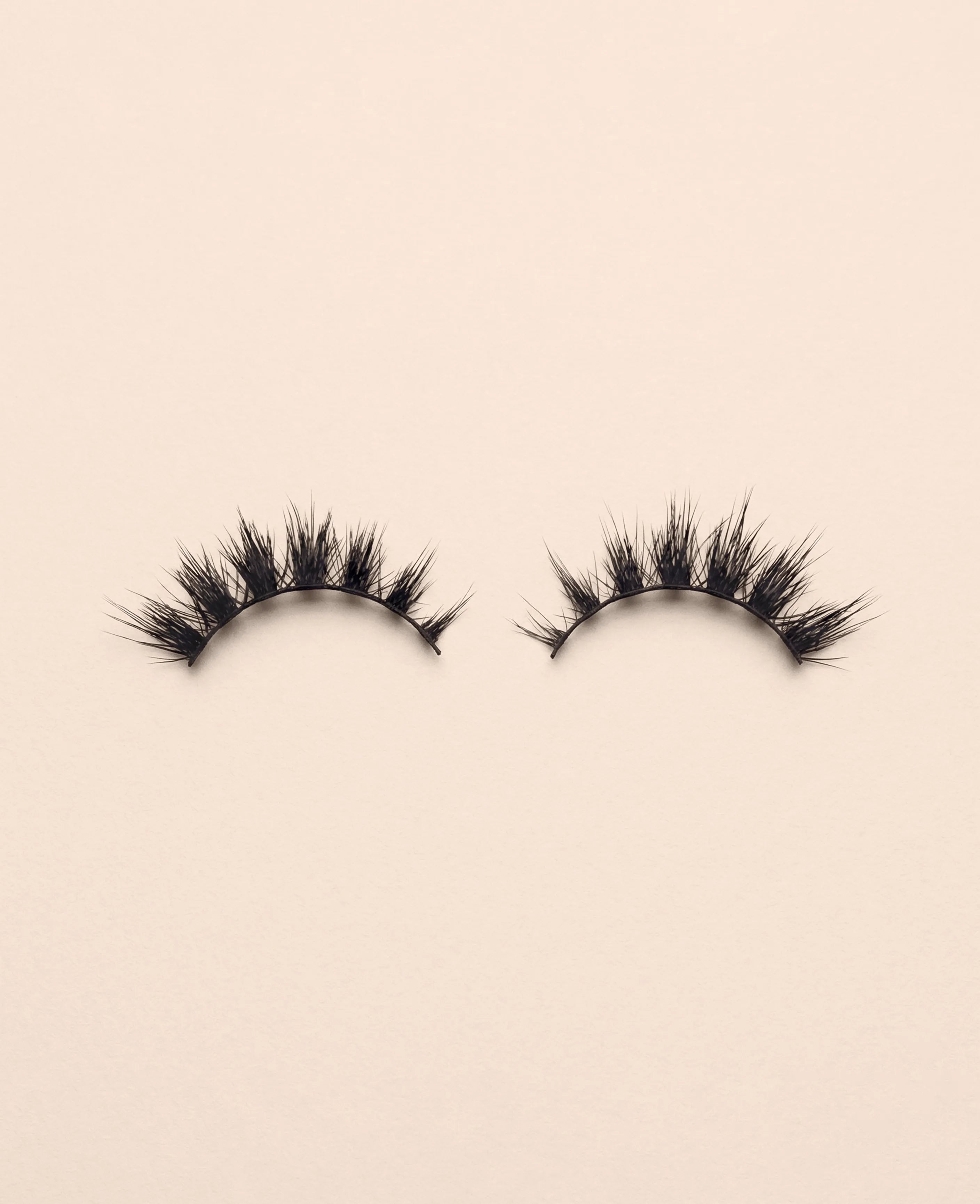Pair of Starlit false eyelashes on a beige background.