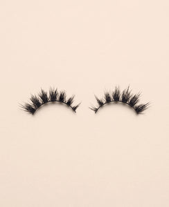 Pair of Starlit false eyelashes on a beige background.