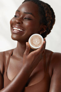 Golden BodyButter - #scent_Unscented #size_8oz - Smiling woman holding an Unscented jar of Elija’s Nature Golden Body Butter 8oz near her face